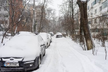 Bükreş 'teki yerleşim yeri Romanya' da şiddetli bir kar fırtınası sonrasında park halindeki araçlar derin karla kaplandı