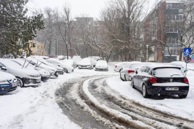 Bükreş 'teki yerleşim yeri Romanya' da şiddetli bir kar fırtınası sonrasında park halindeki araçlar derin karla kaplandı
