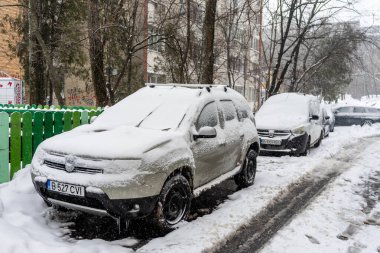 Bükreş 'teki yerleşim yeri Romanya' da şiddetli bir kar fırtınası sonrasında park halindeki araçlar derin karla kaplandı