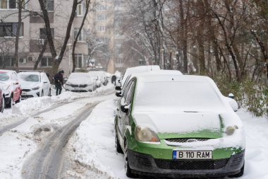 Bükreş 'teki yerleşim yeri Romanya' da şiddetli bir kar fırtınası sonrasında park halindeki araçlar derin karla kaplandı