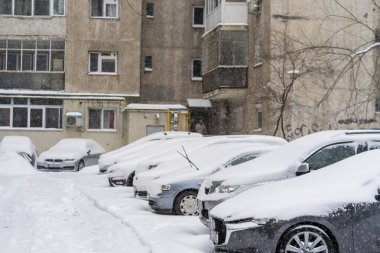 Bükreş 'teki yerleşim yeri Romanya' da şiddetli bir kar fırtınası sonrasında park halindeki araçlar derin karla kaplandı