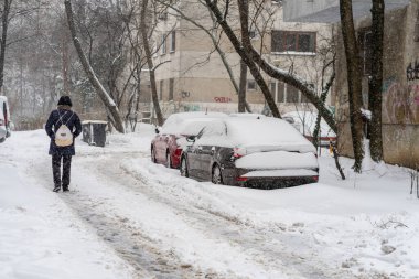 Parked cars covered in deep snow after a heavy winter blizzard in a residential neighborhood of Bucharest Romania