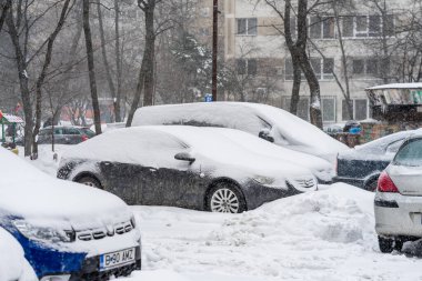 Bükreş 'teki yerleşim yeri Romanya' da şiddetli bir kar fırtınası sonrasında park halindeki araçlar derin karla kaplandı