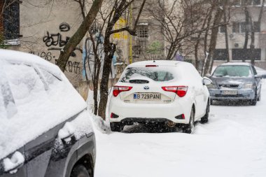 Bükreş 'teki yerleşim yeri Romanya' da şiddetli bir kar fırtınası sonrasında park halindeki araçlar derin karla kaplandı