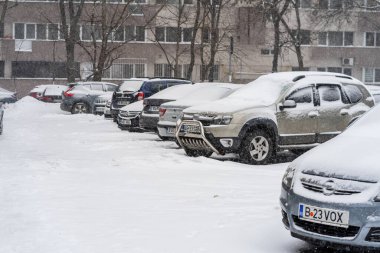 Bükreş 'teki yerleşim yeri Romanya' da şiddetli bir kar fırtınası sonrasında park halindeki araçlar derin karla kaplandı