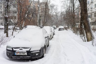 Bükreş 'teki yerleşim yeri Romanya' da şiddetli bir kar fırtınası sonrasında park halindeki araçlar derin karla kaplandı