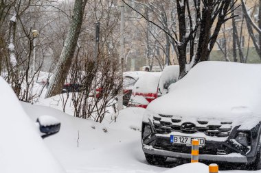 Bükreş 'teki yerleşim yeri Romanya' da şiddetli bir kar fırtınası sonrasında park halindeki araçlar derin karla kaplandı