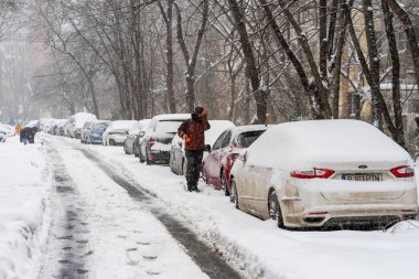 Bükreş 'teki yerleşim yeri Romanya' da şiddetli bir kar fırtınası sonrasında park halindeki araçlar derin karla kaplandı