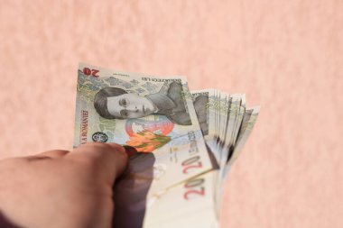Romen para banknotlarını tutan, kağıt doku ve Rumen LEI para biriminin sembollerini gösteren bir adam.
