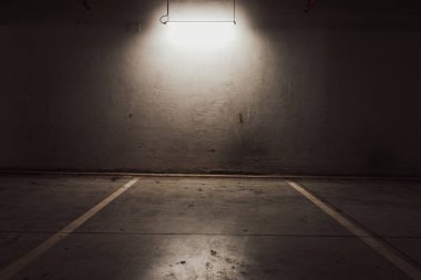 Boş yer altı garajı. Boş park yeri ve loş ışık