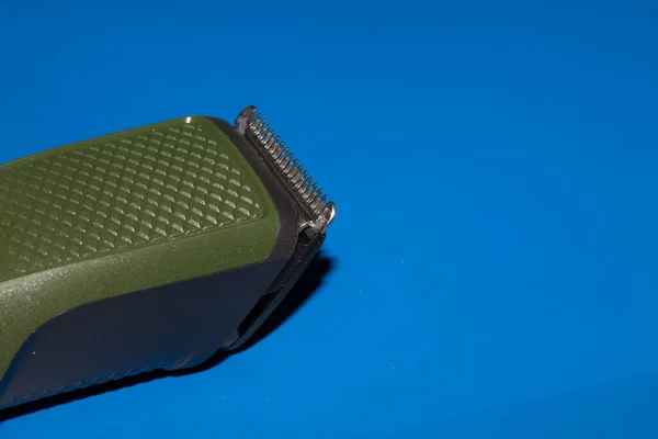 Hair trimmer isolated on the blue background. Beard and hair clippers.