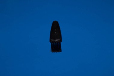 Saç kesme fırçası mavi arka planda izole edilmiş. Sakal ve saç makası..