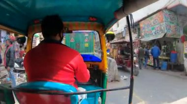 Otomobil Rickshaw (Tuk Tuk) 'un içinde Chandni Chowk Caddesi' nde trafik ve insan dolu arka koltuktan ateş edildi.