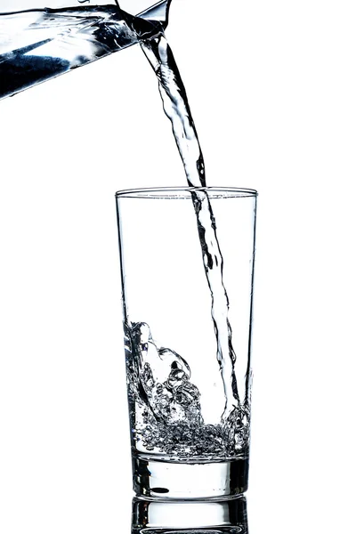 Clean water poured from a jug into a glass — Stock Photo, Image