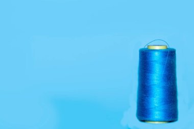 Büyük ve küçük mavi iplik makaralı bir arka plan. Mavi arka planda yan yana yatarlar. Seçici odak