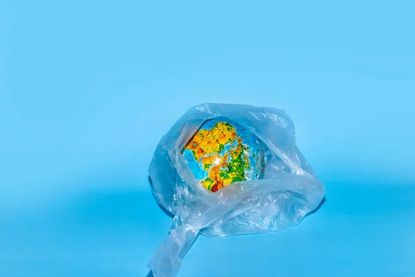 Conceito Ecologia Globo Plástico Envoltório Sobre Fundo Azul Resíduos Plásticos — Fotografia de Stock