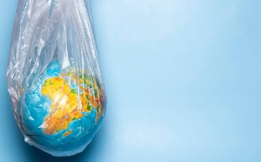 Ekoloji kavramı. Mavi arka planda plastik ambalajlı bir dünya. Plastik atık çevre kirliliği kavramı. Metin için yer.