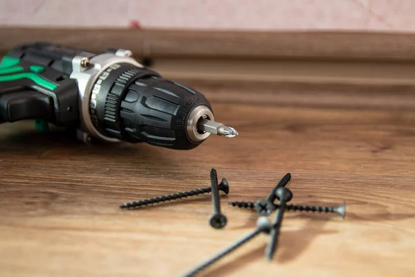Self-tapping screws with a cordless drill. Selective focus. The concept of tools and repair work. — Stock Photo, Image