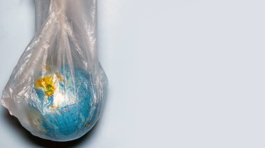 Ekoloji konsepti. Mavi arka planda plastik ambalajlı bir dünya. Plastik atık çevresel kirlilik kavramı. Metin için yer.