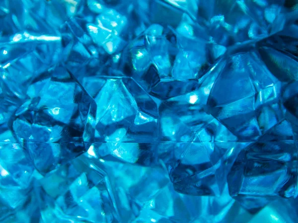 Bright blue crystals made of glass look like gems close-up in the blur. Background from blue stones crystals.