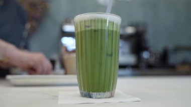 Arka planda yumuşak odaklı kadın barmen aktivitesi olan bir bar masasında bir bardak kibrit.