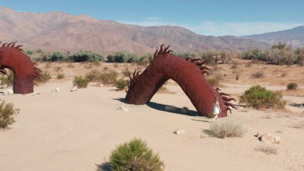 Attraktive Frau erkundet Metallskulptur des Drachen in der Wüste Anza Borrego, — Stockvideo