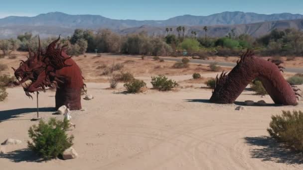 Uma mulher a correr no deserto de Anza Borrego. Menina andando em escultura gigantesca de dragão — Vídeo de Stock