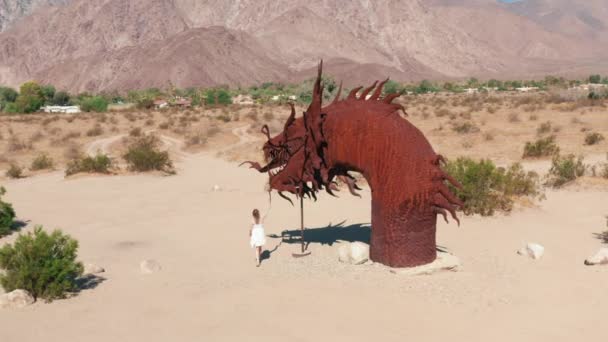 Anza Borrego Çölü 'ndeki devasa gragon heykelinin önünde yürüyen kadın. — Stok video