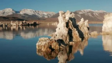 Mavi yüzeye yansıyan inanılmaz turna taşları etrafında hareket eden kamera, 4K