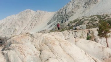 Dağları seven bir kadın ellerini havaya kaldırıyor özgürlükten mutlu bir şekilde.