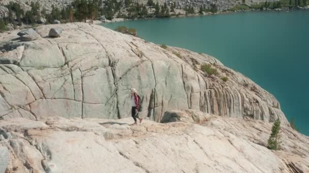 Γυναίκα ορειβασία στη λίμνη βουνό. Αεροφωτογραφία του ορεινού τοπίου με γαλάζια λίμνη — Αρχείο Βίντεο