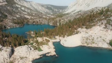 4K hava manzaralı güzel mavi ve yeşil dağ gölü üzerinde uçan insansız hava aracı