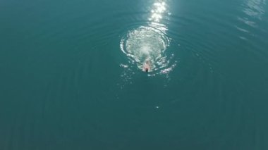 Buz gibi dağ mavisi gölde yüzen cesur kadın. Buzul gölünde yüzmek