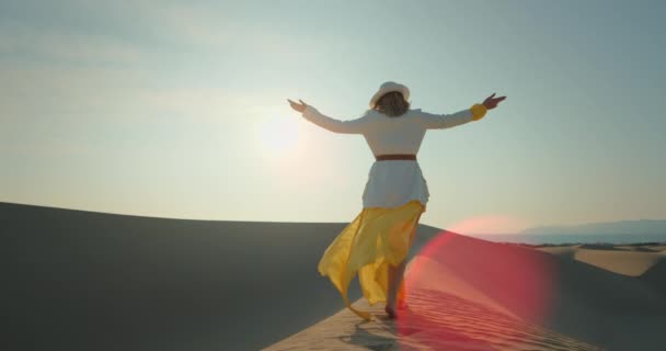 해질 때 사막을 맨발로 걷는 젊은 여자. 손들고 있는 예쁜 숙녀 — 비디오