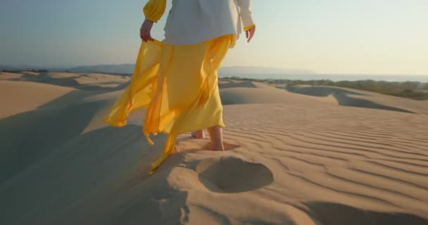 Женщины ходят босиком по волнистой песчаной дюне в пустыне — стоковое видео