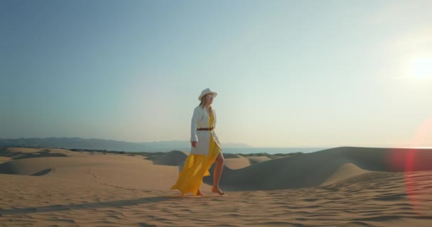 Romantyczna kobieta spacerująca samotnie po pustyni o zachodzie słońca — Wideo stockowe