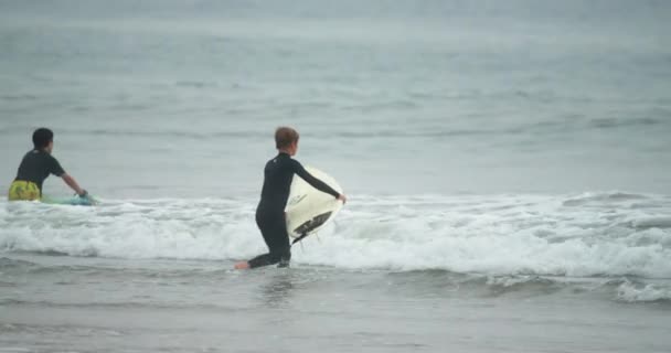 Młody surfer jedzie na piankowej fali — Wideo stockowe