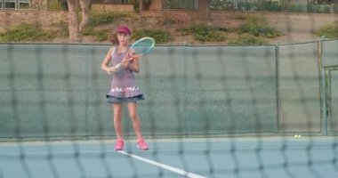Raketle sarı tenis topuna vuran kız.
