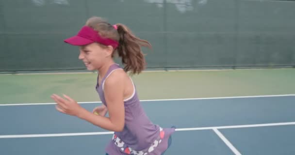 Tiener beweegt snel als ze verzamelt tennisballen — Stockvideo
