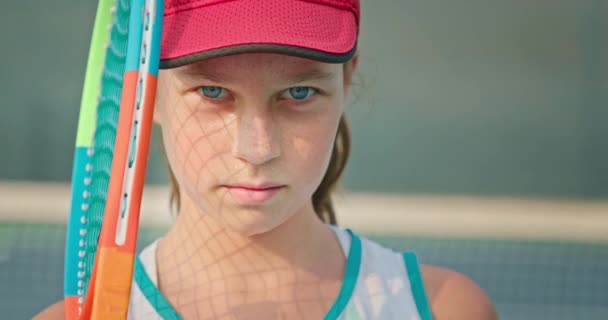 Redheaded έφηβος κρατώντας ρακέτα τένις και κοιτάζοντας την κάμερα — Αρχείο Βίντεο
