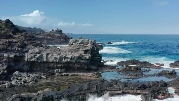 Sinematik gök mavisi, mavi, yeşil turkuaz dalgalar manzaralı volkanik kayalara çarpıyor. — Stok video