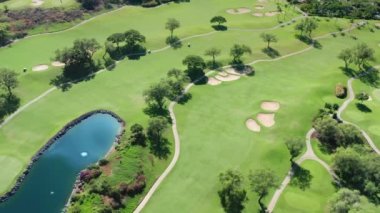 Golf sopası atış yapıyor. Yeşil golf sahası geçmişi. Gökyüzü mavi göl
