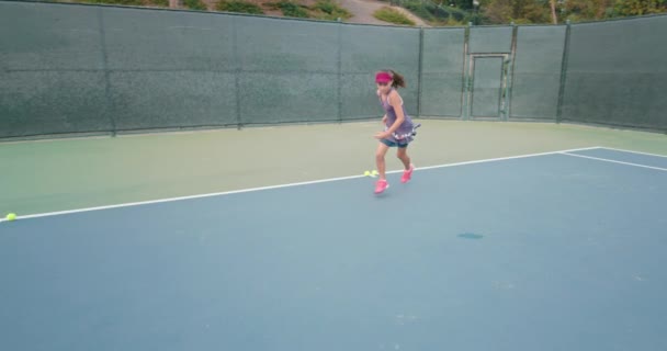 Tennis player wearing purple dress running along the court — Stock Video