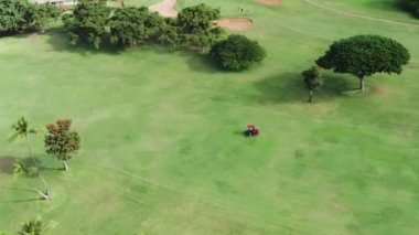 Çim biçme makinesinde sinematik manzara manzaralı golf sahasında yeşil çimleri kesiyor. 4K USA
