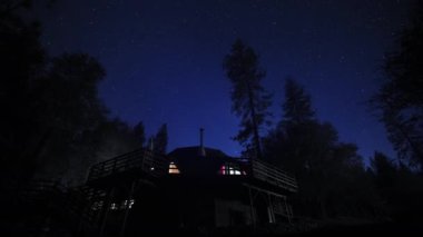 Ormandaki sıcak kubbenin üzerinde gece vakti parlayan yıldızların manzarası.