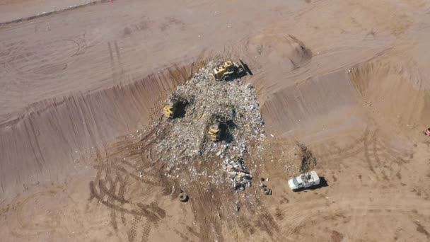 Eine Müllpresse, eine Gruppe von Arbeitern, die den Müll im Boden vergraben. USA — Stockvideo
