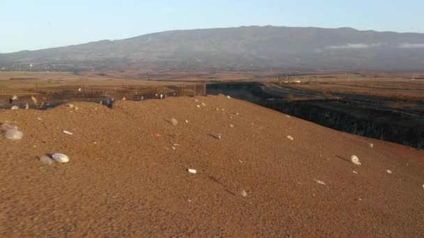 Cierre la basura plástica restante que vuela el viento en la colina del vertedero al atardecer, 4K USA — Vídeo de stock