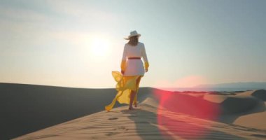 Safari gezisi sırasında çölde seyahat eden genç bir bayan. Çıplak ayakla yürüyen kadın.