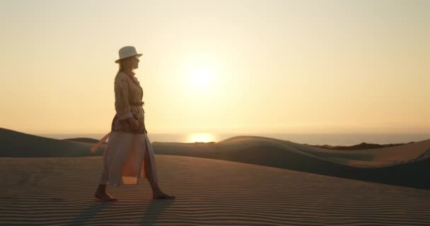 Chica solitaria caminando descalza sobre una duna ondulada en el desierto. — Vídeos de Stock