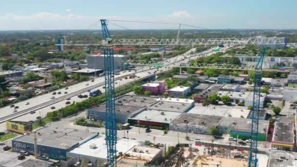 Промышленная строительная площадка с воздушным видом на краны, работающие на строительстве в городе — стоковое видео